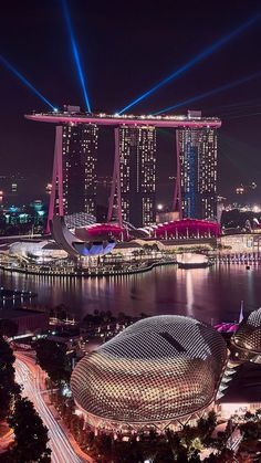 an aerial view of the marina bay area at night, with lights shining in the background