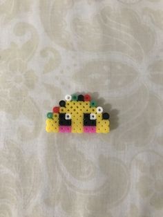 a yellow and black beaded animal sitting on top of a table