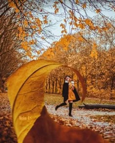 a woman is walking in the park with an umbrella