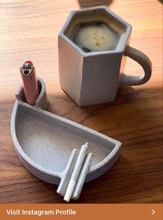 a coffee cup and pen holder on a table