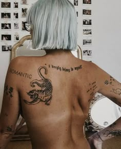 a woman with white hair and tattoos on her back