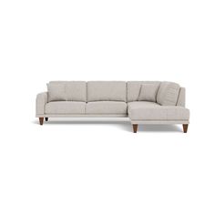 a white sectional couch with wooden legs and pillows on it's back, facing the camera