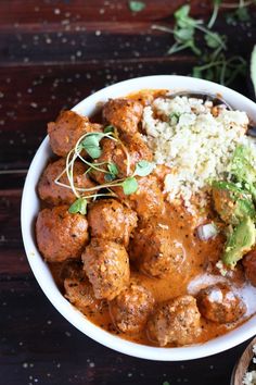 a white bowl filled with meatballs and rice