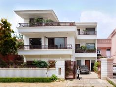 a car parked in front of a two story house with balconies and balconyes