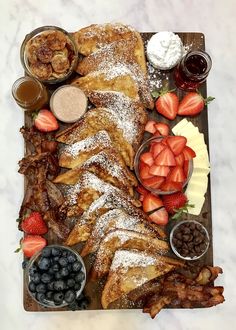 a platter filled with french toast, strawberries and other foods