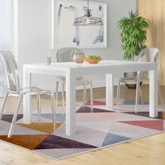 a white table with two chairs and a potted plant in the corner next to it