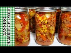 four jars filled with food sitting on top of a table