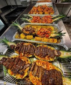 several trays filled with different types of food on top of a table next to each other