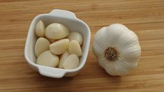 an onion and garlic in a bowl on a wooden table