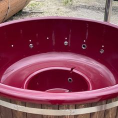 a red hot tub sitting on top of a wooden barrel