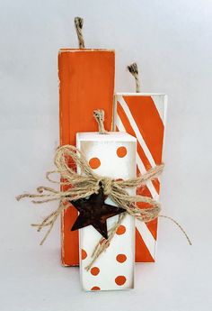 three orange and white boxes tied with twine, one has a black star on it