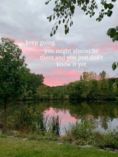 a lake with trees in the foreground and a quote on it that reads keep going you might almost be there and you just don't know it yet