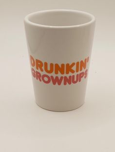 a white cup with the words drunk brownies written on it's side and an orange stripe across the bottom