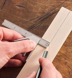 a person is measuring wood with a ruler