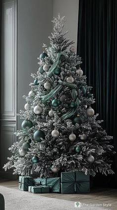 a white christmas tree with green and silver ornaments