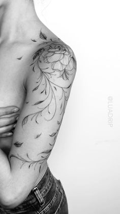 black and white photograph of a woman's arm with flowers on it, in front of a white background