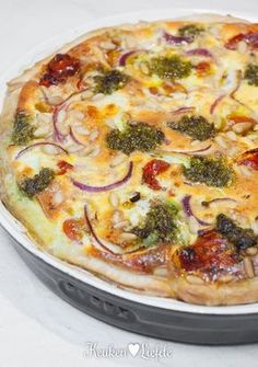 a pizza sitting on top of a pan covered in cheese and veggie toppings