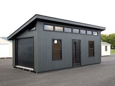 a small gray building sitting on top of a parking lot