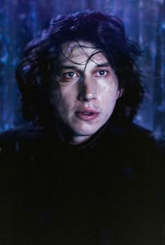 a close up of a person in a dark room with snow on the ground and trees behind him