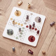 a board game sitting on top of a wooden floor next to buttons and push pins