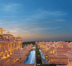 an aerial view of the buildings and pool at dusk, with blue skies in the background