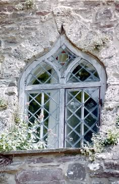 an old stone building with a window and flower box