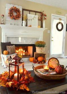 a living room decorated for fall with candles, pumpkins and other autumn decor items