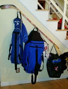 two backpacks are hanging on the wall next to some ski poles and snowboards