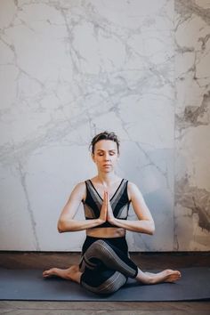 a woman is sitting in the middle of a yoga pose