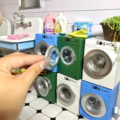 a hand is touching the buttons on several washing machines