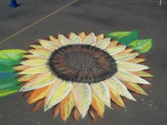 a sunflower painted on the ground with leaves