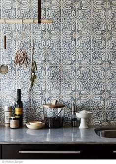 a kitchen counter with utensils hanging from the wall