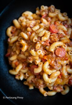 pasta with sausage and tomato sauce in a black bowl