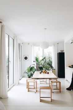 a person sitting at a table in a room with white walls and flooring,