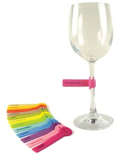 a wine glass with several colored markers on it and a bottle opener in the foreground