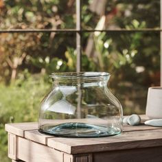 an empty glass jar sitting on top of a wooden table