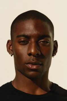 a close up of a person wearing a black shirt and ear piercings on his ears