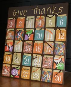 a square wooden calendar with the words give thanks written in white on it and numbers painted on each side