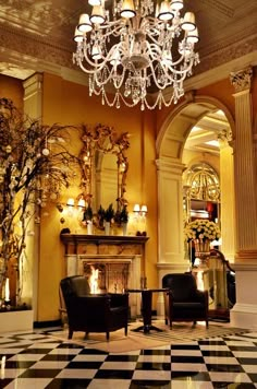 a fancy hotel lobby with chandelier and fireplace