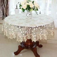 a vase with white flowers sitting on top of a table in front of a window