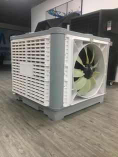 an industrial air conditioner sitting on top of a hard wood floor in a building