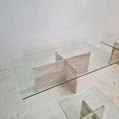 three glass tables sitting on top of each other in front of a white wall and floor