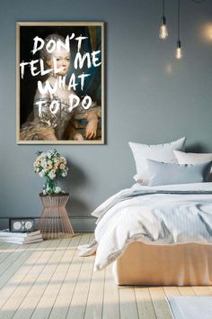 a bedroom with a bed, nightstand and poster on the wall that says don't tell me what to do