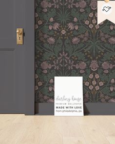 an open door with a sign on it in front of a wallpapered background