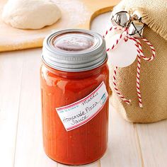 a jar filled with homemade tomato sauce next to a bag of breadcrumbs