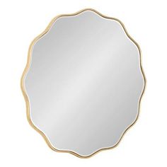 a round mirror with gold trimmings on the edges and an oval shaped frame