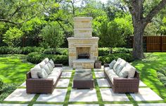 an outdoor living area with couches and a fire place in the middle of it