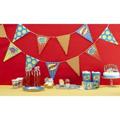 a table topped with cake and drinks next to a red wall