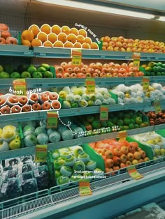 an assortment of fruits and vegetables on display in a grocery store, labeled with labels