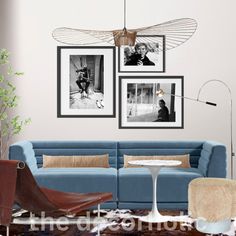 a living room with blue couches and pictures on the wall above them in black and white